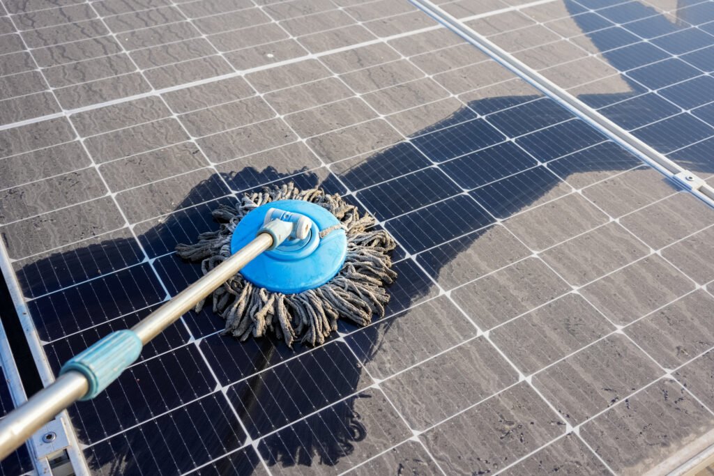 Man clean up the solar panels that are dirty with dust and birds' droppings to improve the efficiency of solar energy storage.